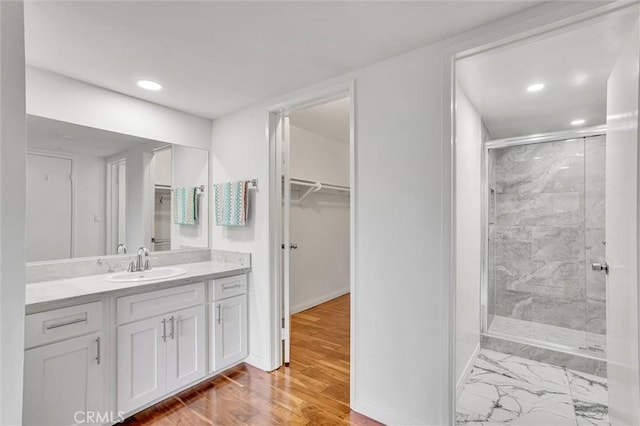 bathroom with a shower with shower door and vanity