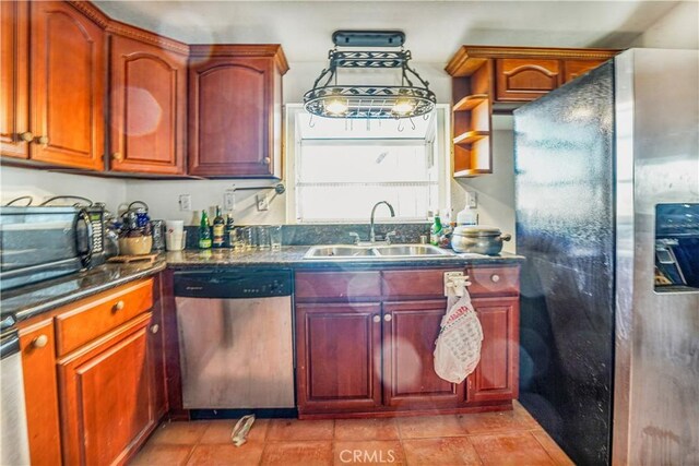 kitchen featuring dark stone counters, appliances with stainless steel finishes, sink, and light tile patterned flooring