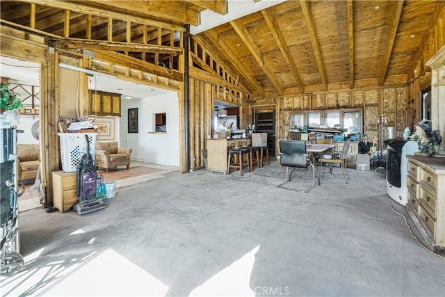 misc room featuring high vaulted ceiling and concrete floors