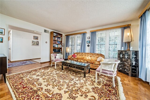 living room featuring light parquet flooring and a textured ceiling