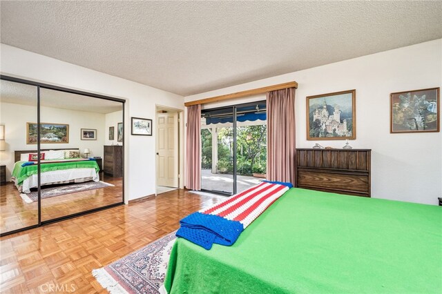 bedroom with access to exterior, a textured ceiling, and parquet floors