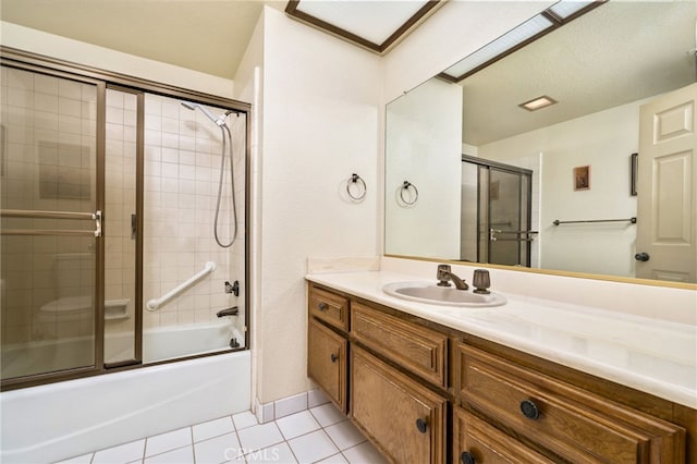 bathroom featuring bath / shower combo with glass door, tile patterned flooring, and vanity