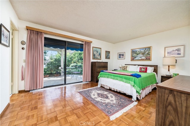 bedroom featuring light parquet flooring, access to exterior, and a textured ceiling