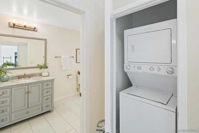 washroom featuring light tile patterned floors, sink, and stacked washer / drying machine