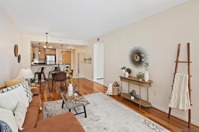 living room with wood-type flooring and an inviting chandelier