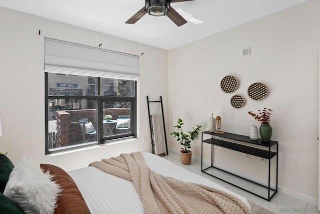 tiled bedroom featuring ceiling fan