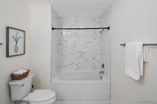 bathroom with toilet, tiled shower / bath, and tile patterned flooring