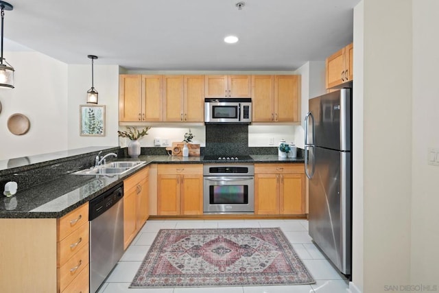 kitchen featuring light tile patterned floors, stainless steel appliances, decorative light fixtures, dark stone counters, and sink