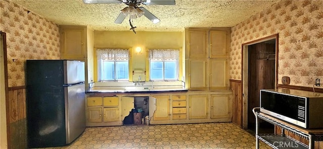 kitchen featuring ceiling fan, appliances with stainless steel finishes, and a textured ceiling