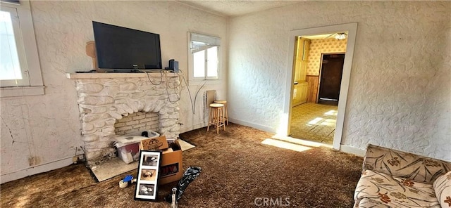 carpeted living room featuring a stone fireplace