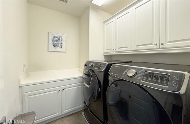 clothes washing area featuring tile patterned flooring, visible vents, cabinet space, and independent washer and dryer