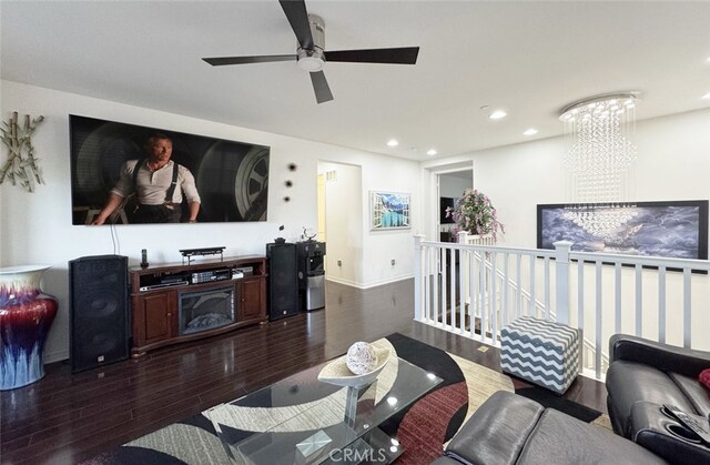 living area with recessed lighting, baseboards, dark wood-type flooring, and an inviting chandelier