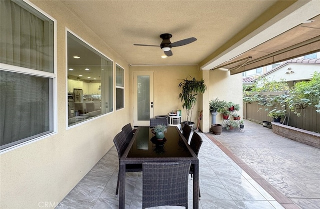 view of patio / terrace with ceiling fan and fence