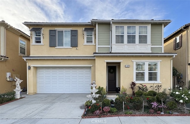 view of property with stucco siding, an attached garage, and driveway