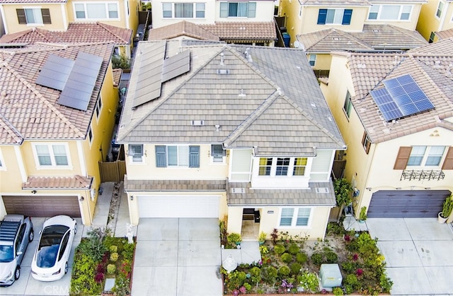 view of front facade featuring a residential view, a tile roof, concrete driveway, stucco siding, and a garage