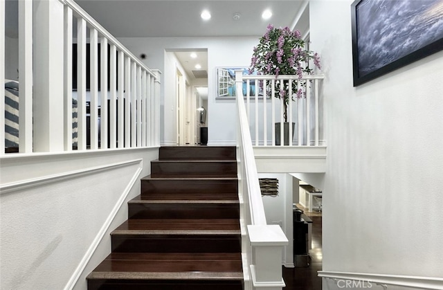 staircase with recessed lighting and wood finished floors