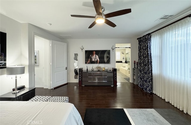 bedroom featuring connected bathroom, wood finished floors, visible vents, and ceiling fan