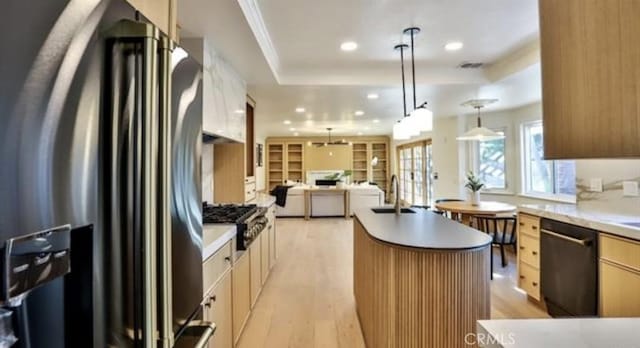 kitchen with sink, appliances with stainless steel finishes, pendant lighting, and a center island