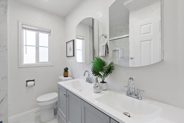 bathroom featuring vanity, a shower with door, and toilet