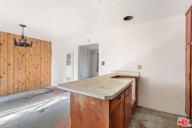 kitchen featuring decorative light fixtures, kitchen peninsula, and wooden walls