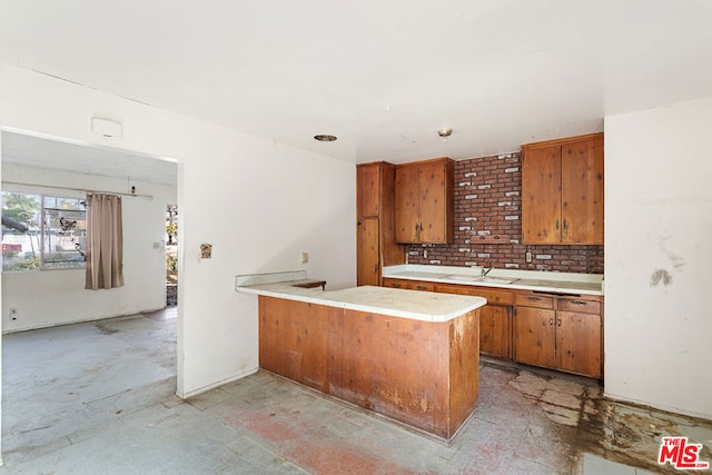 kitchen featuring decorative backsplash, sink, and kitchen peninsula