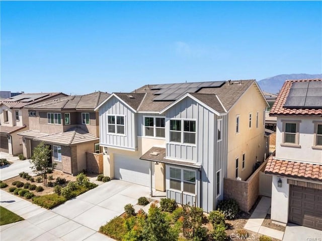 townhome / multi-family property featuring a mountain view, solar panels, and a garage