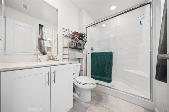 bathroom with an enclosed shower, vanity, tile patterned flooring, and toilet