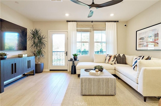 living room featuring ceiling fan and light wood-type flooring