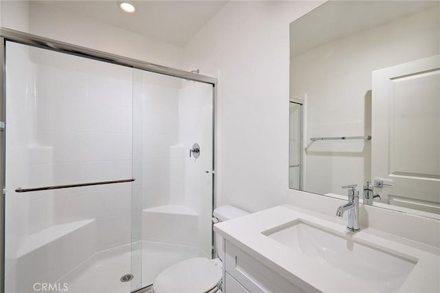 bathroom featuring vanity, toilet, and an enclosed shower