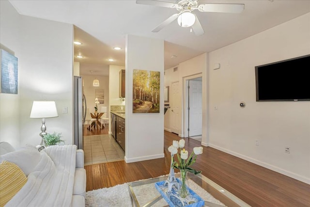 living room featuring ceiling fan and light wood-type flooring