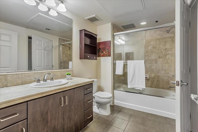 full bathroom with tile patterned floors, toilet, combined bath / shower with glass door, and vanity