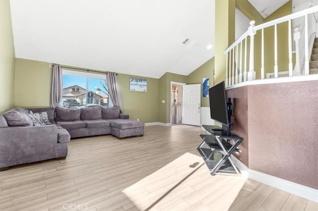 living room with vaulted ceiling and light hardwood / wood-style floors