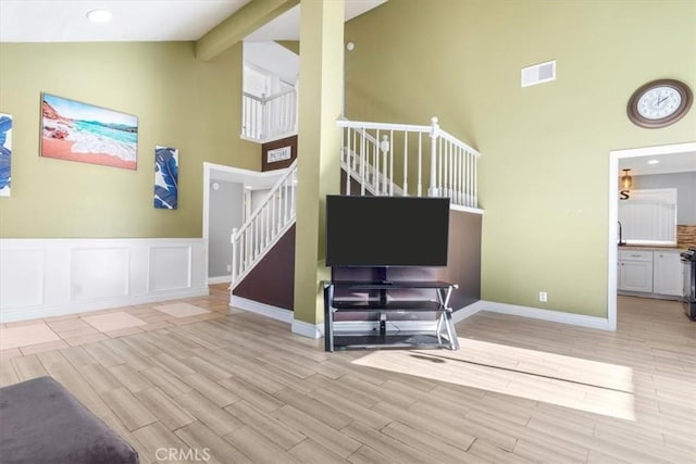 living room featuring high vaulted ceiling and light hardwood / wood-style floors