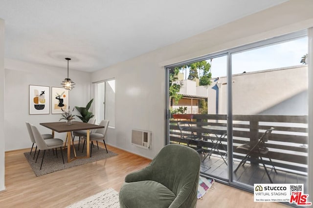 dining space featuring a wall mounted AC and hardwood / wood-style flooring