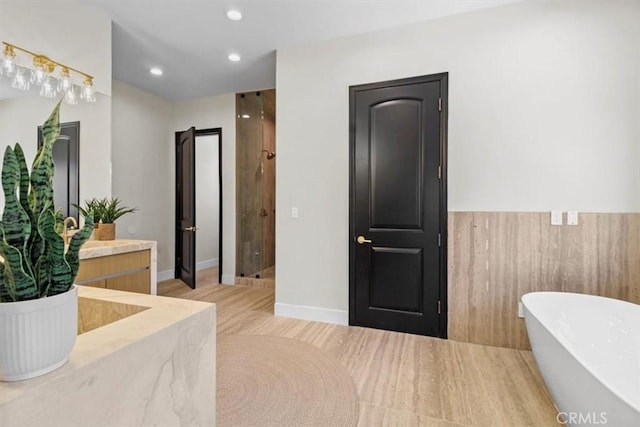 bathroom with vanity, hardwood / wood-style flooring, and shower with separate bathtub