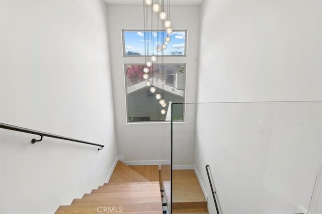 stairway featuring a chandelier