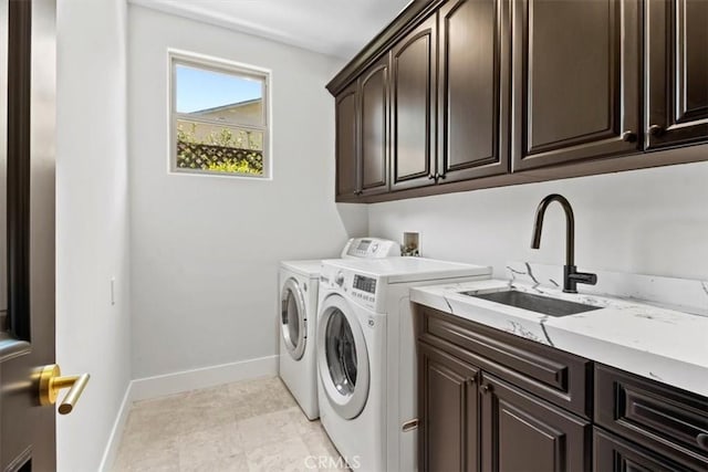 laundry room featuring washer and dryer, sink, and cabinets