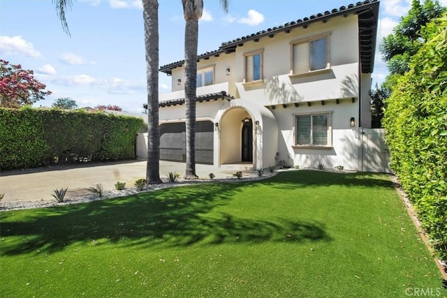 mediterranean / spanish-style house featuring a garage and a front yard