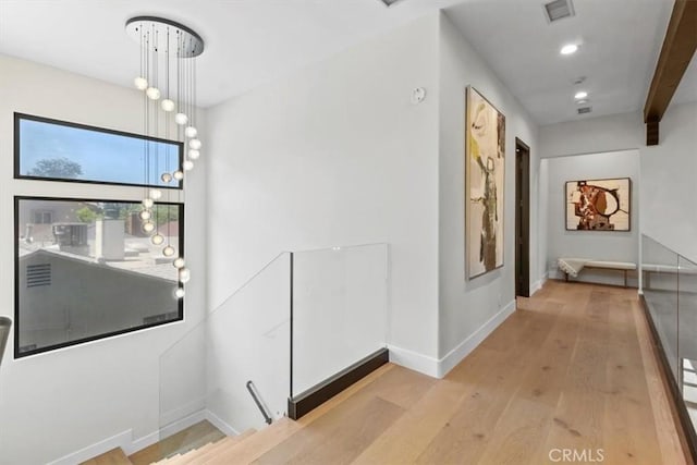 corridor featuring light hardwood / wood-style flooring and beamed ceiling