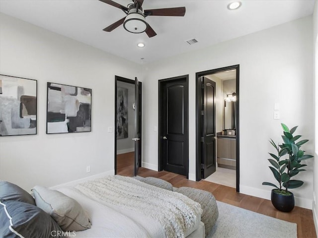 bedroom featuring ceiling fan, ensuite bathroom, and hardwood / wood-style flooring