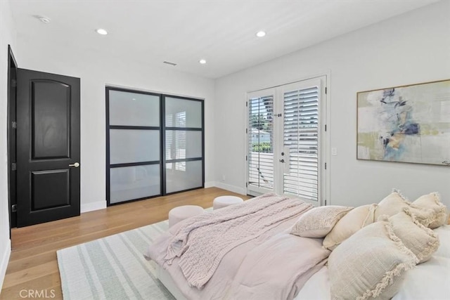 bedroom with access to exterior, light hardwood / wood-style floors, and french doors