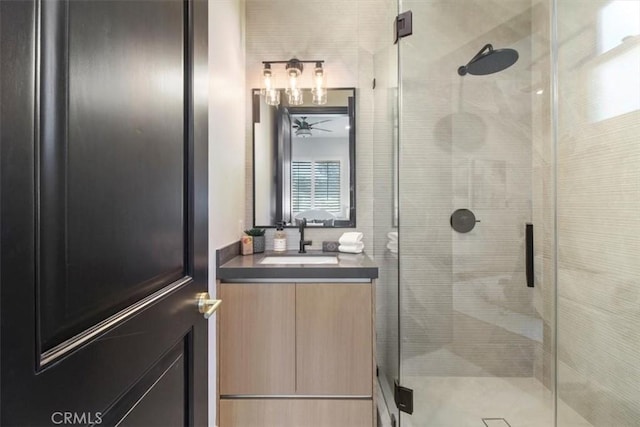 bathroom featuring ceiling fan, vanity, and an enclosed shower