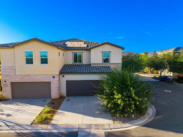 mediterranean / spanish-style home featuring a garage and solar panels