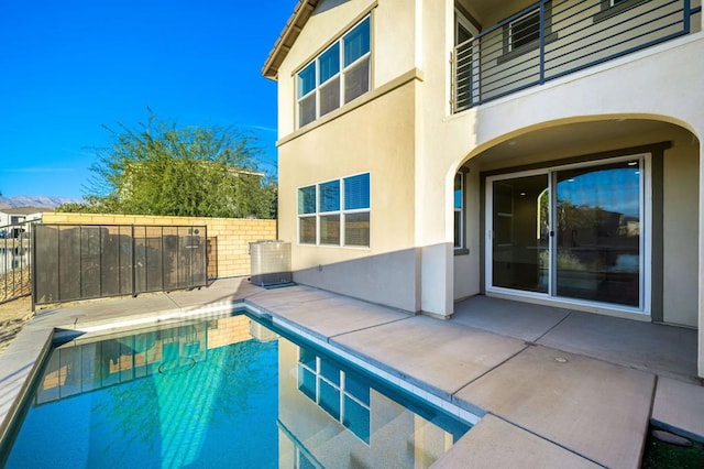 view of swimming pool with cooling unit and a patio