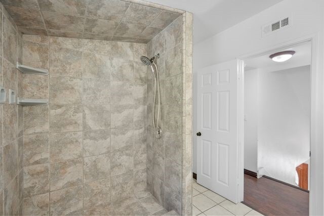 bathroom featuring tile patterned floors and a tile shower