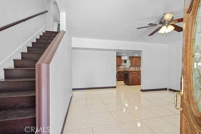 stairs featuring ceiling fan and tile patterned flooring