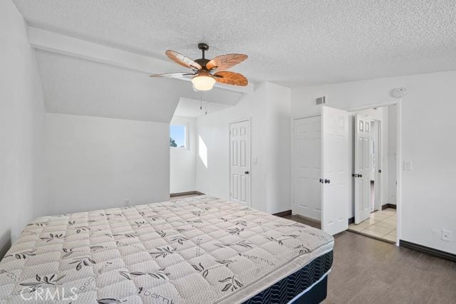 bedroom featuring a textured ceiling, ceiling fan, and vaulted ceiling