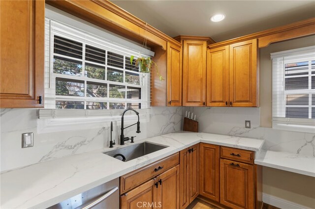 kitchen with light stone countertops, sink, and tasteful backsplash