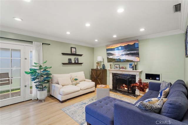 living room with crown molding and light hardwood / wood-style flooring