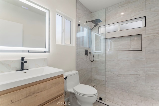 bathroom with toilet, vanity, and a tile shower